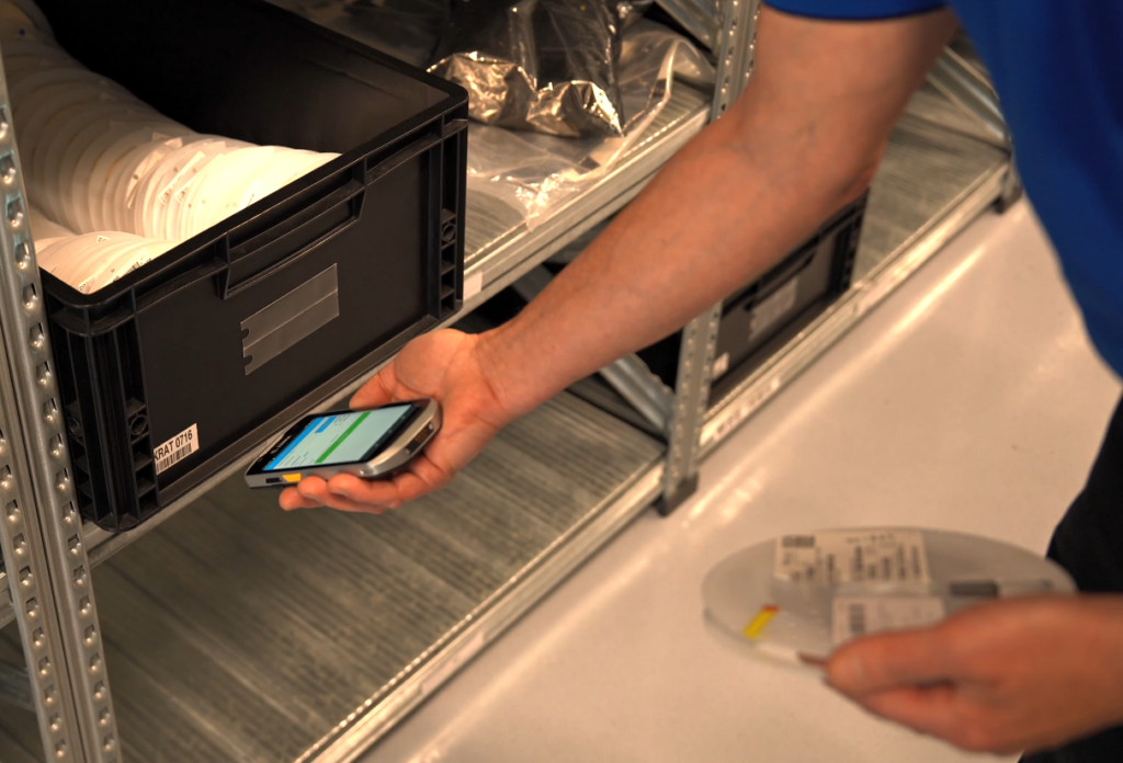 Un employé scanne une bobine de composants SMT lors de son enregistrement dans le système de gestion des stocks ESSEGI, afin d'assurer une traçabilité complète.