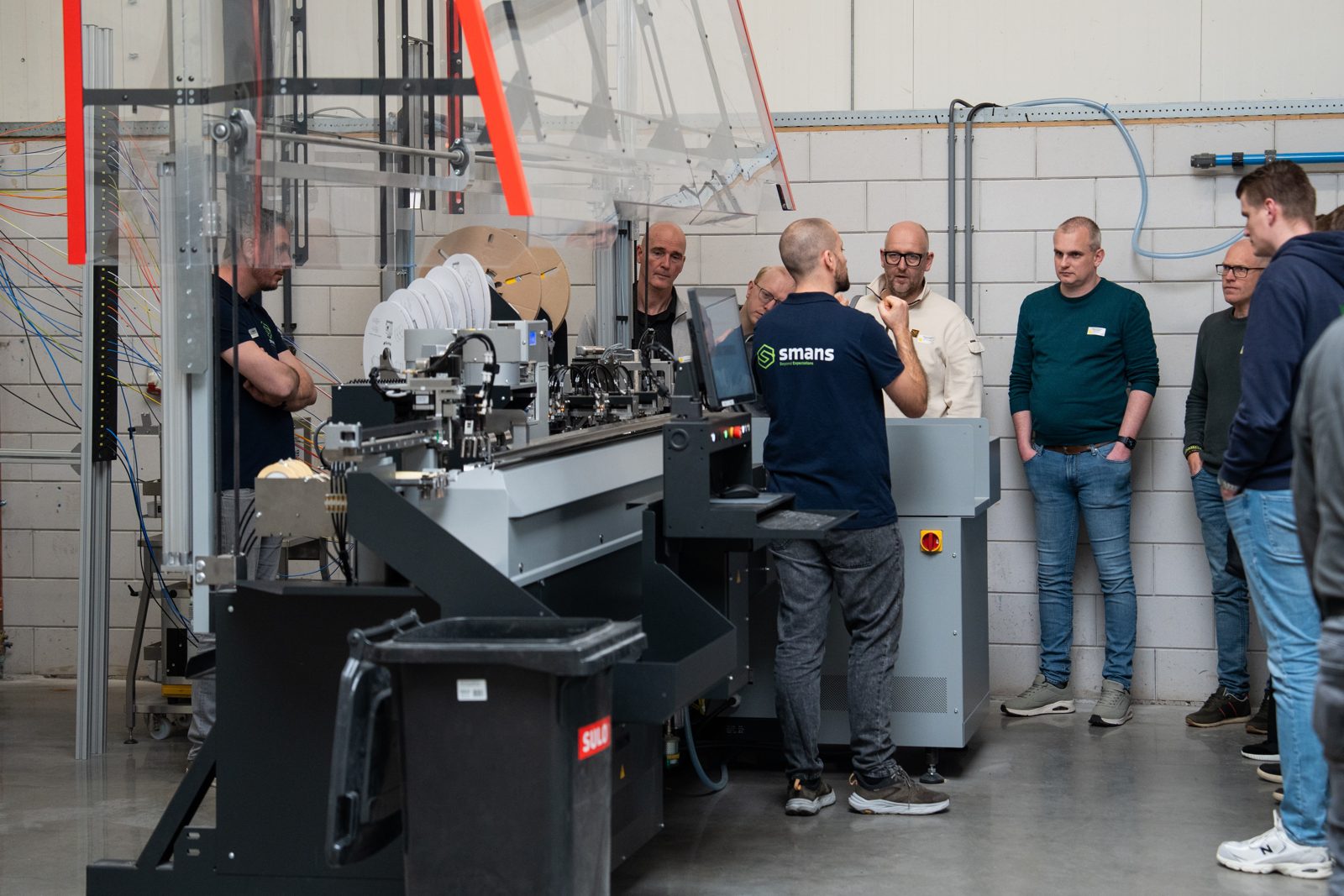 Bezoekers bekijken de Komax Zeta 640 tijdens een demo bij Smans